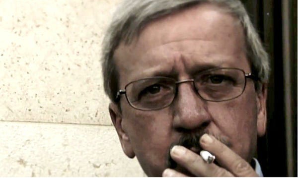 In this video frame from a Herman Cain ad, campaign chief of staff Mark Block is shown smoking a cigarette.
