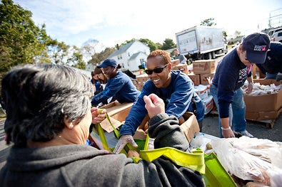 Frances Joseph, a volunteer, distributed free food at the Mobile Pantry in Quincy, Mass.