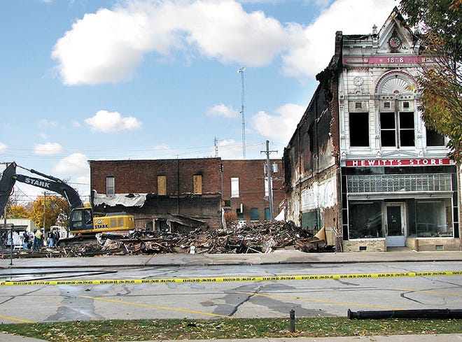 The Hewitt building still stands Thursday morning on Chestnut Street in downtown Minonk as cleanup efforts take place next door in the wake of a fire that destroyed four structures Wednesday. Later Thursday, workers began to raze the Hewitt building, which was built in 1888. The building sustained damage in the fire. As a result, an adjacent structure that houses a grocery store was threatened.