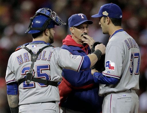 Texas Rangers pitching coach Mike Maddux talks to Mike Adams (37) and Mike Napoli (25) during the eighth inning of Game 2 of baseball's World Series against the St. Louis Cardinals Thursday, Oct. 20, 2011, in St. Louis. (AP Photo/Charlie Riedel)