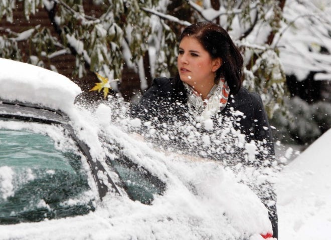 Lindsay Vassar brushes snow from her automobile in Denver on
Wednesday. A fast- moving snowstorm created blizzard conditions in
parts of Eastern Colorado on Wednesday.