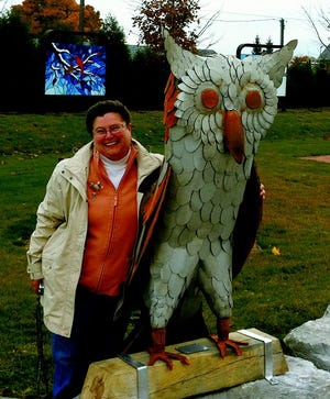 Ann Gildner, an artist and director of the Gildner Gallery in Cheboygan, poses with the new display at Ottawa Park. The Moran Iron Works’ Owl was placed close to the intersection of North Main and State streets early on Thursday morning.