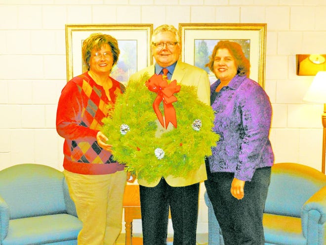 Megan Grant, Michael Lewis and Sherry Waite display one of the wreaths they are selling to help raise money to purchase a critical piece of equipment.