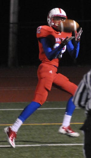 Natick's Alex Hilger catches a pass in the end zone for a Red and Blue touchdown last night.