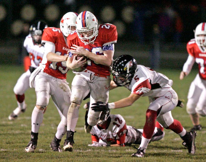 Oregon High School's Casey Howard (26) runs the ball as Aurora Christian's Noah Roberts (5) dives for a tackle in the second quarter Friday, Nov. 4, 2011, during their game in the second round of the IHSA Class 3A Playoffs in Oregon.