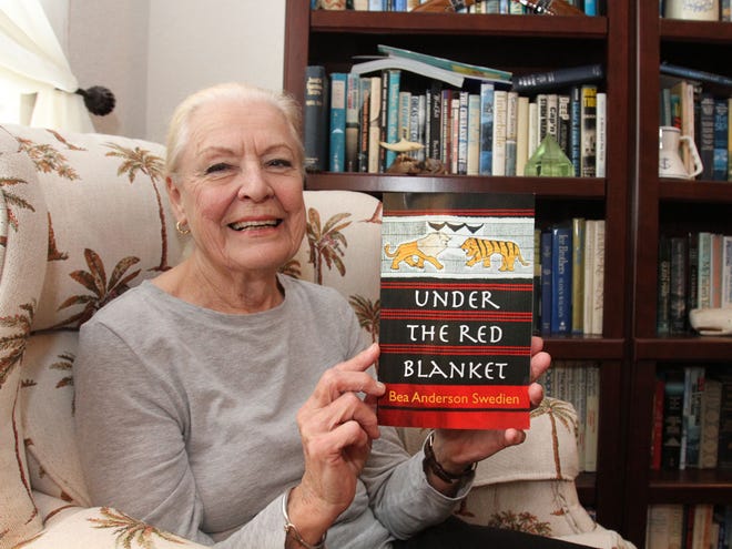 Author Bea Anderson Swedien poses with her new book, "Under The Red Blanket," at her northeast Ocala home on Monday, Oct. 31, 2011.