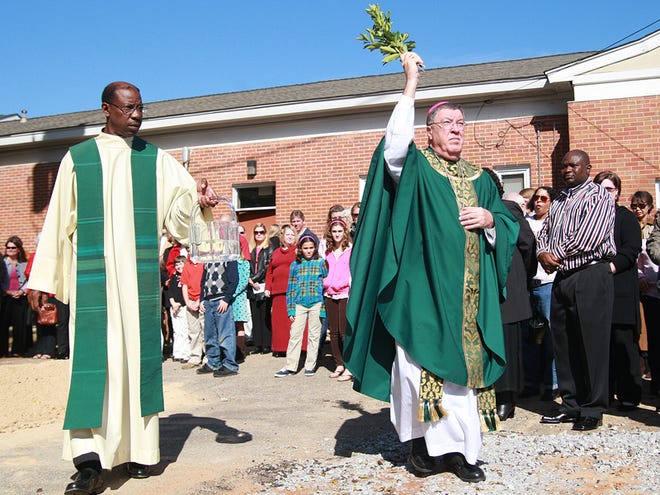 The Most Rev. Robert J. Baker, left, and the Rev. Gerald Holloway bless the construction site of the future home of St. Francis of Assisi University Parish on the University of Alabama campus on Sunday morning.