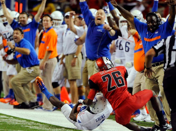 Boise State cornerback Jerrell Gavins makes an interception in front of Georgia wide receiver Malcolm Mitchell (26) as the Boise State bench celebrates during the first half of the teams’ opening season game at the Georgia Dome in Atlanta on Sept. 3. The newly-minted 14-team SEC faces potentially sticky scheduling issues if it goes to a larger divisional slate, tries to protect rivalries and keep marquee nonconference showdowns. (David Tulis | Associated Press)