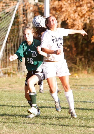 East Bridgewater High School's Melissa Figueireda (12) competes with Duxbury High School's Lily Connolly (26) to head the ball during the game in East Bridgewater on Wednesday, November 9, 2011.