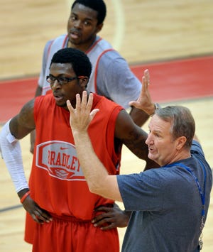 Assistant coach Greg Graham works with players Taylor Brown and Jalen Crawford.