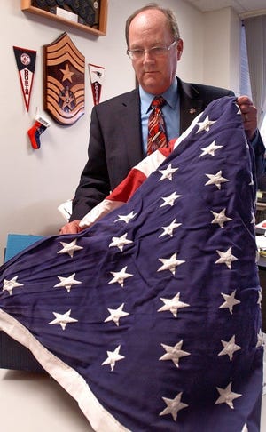 Walter Tafe in his office inside the Human Resource Building in
Westampton, folding an old American flag that will be destroyed
properly in mid-November. He is director of Military and Veterans
Affairs in Burlington County.