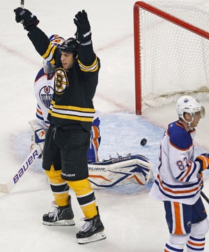 Boston Bruins left wing Milan Lucic celebrates a goal by teammate Johnny Boychuk as Edmonton Oilers right wing Ales Hemsky skates away during the first period of an NHL hockey game in Boston, Thursday, Nov. 10, 2011.