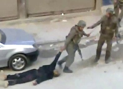 An amateur video released by the Shaam News Network shows a soldier dragging a body on Thursday in Damascus, Syria.