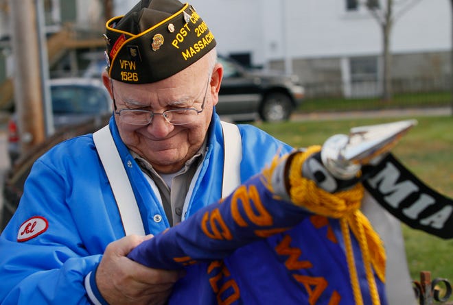 Commander Al Holmes rolls up his flag after the Veterans Day ceremony yesterday morning in Medway.