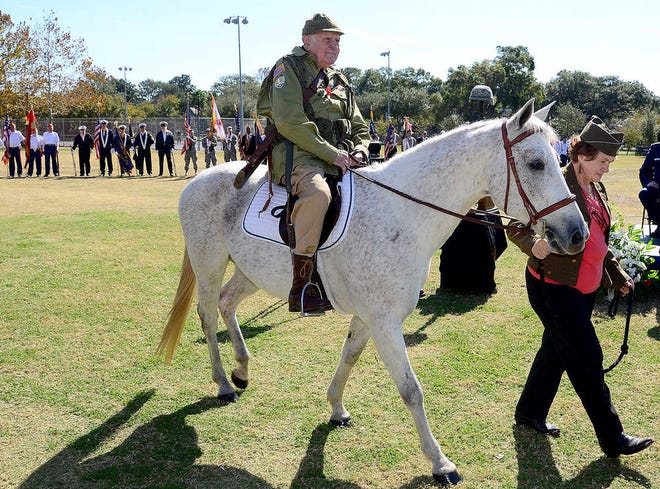 World War II veteran Mario Patruno, 90, rides a horse led by Shirley Mayo during a Veteran's Day celebration held in St. Augustine on Friday. Patruno parachuted into France with the 82nd Airborne Division during D-Day in 1945. When he got separated from his unit after the jump he stole a horse like the one he rode Friday from a German officer and rode it back to his unit.