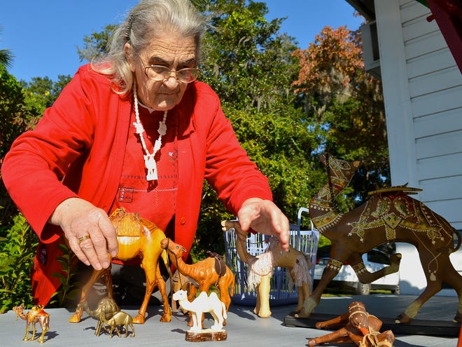 Annabelle Dobbs, longtime parishioner at United Methodist Church in Dunnellon, Fla., arranges some of her camel figurines during the First Saturday Village Market Nov. 5, outside the Community Thrift Shop where she is a volunteer.