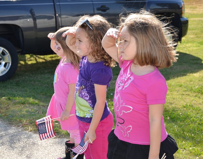 Madison Commander age 4, Zahra Walker age 5, and Mallory Commander age 5, stand to salute veterans during Sunday's parade.