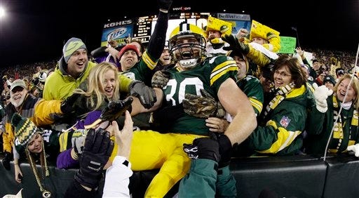 Green Bay Packers' John Kuhn celebrates with fans after catching a touchdown pass during the second half of an NFL football game against the Minnesota Vikings on Monday, in Green Bay, Wis.