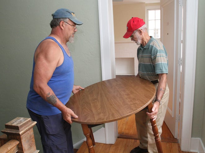 Bob Haney, left, and Bob Vandeventer, both of Point Man Ministries, carry a table into one of the rooms as they help furnish the apartments at The Ocala Ritz Veterans Village (formerly The Ritz Historic Inn) on East Silver Springs Boulevard in Ocala on Wednesday.