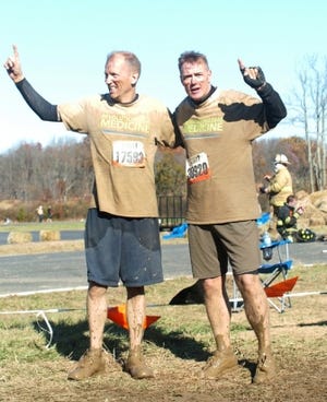 Dave Scanlon, left, and John Reilly afer competing the "Fire Walker" obstacle at Mile 7 of Tri-State Tough Mudder.