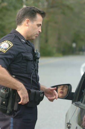 Easton police officer Robert Tuohy speaks with a driver after he stopped a vehicle at the Easton Five Corners on Friday, Sept. 30, 2011.