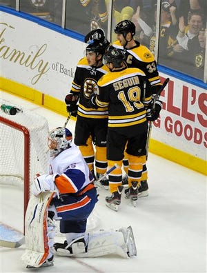 Brad Marchand, Zdeno Chara (33) and Tyler Seguin (19) celebrate Chara's goal as Islanders goalie Anders Nilsson reacts in the third period of the Bruins' 6-0 victory on Saturday night in Uniondale, N.Y.