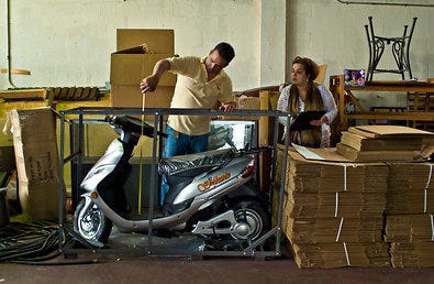 Alain Tristan and his sister Marlen, who run a shipping company catering to Cuban-Americans, measured a scooter for packing.