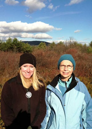 With Mount Wachusett in the background, Sarah Wells, left, an AmeriCorps worker for Mount Grace Land Conservation Trust, and Janet Morrison, executive director of the North County Land Trust, discuss the Forest Legacy Grant.