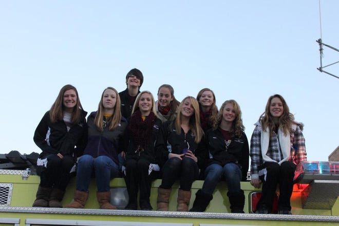 The Dunlap girls Sectional and State swimmers pose on top of a Dunlap fire truck Monday morning. The truck took the girls to school with the sirens and lights on to celebrate their season.