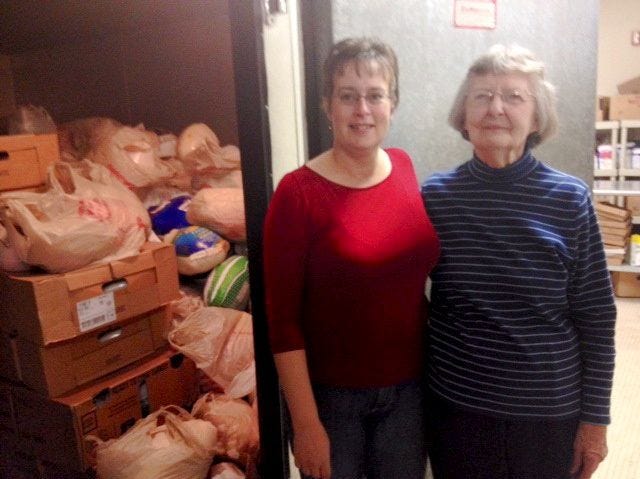 Curtis/Democrat photo
Lisa Fernald (left) and Anne Ackerson, coordinators of Gerry's Food Pantry, stand in front of the giant freezer that is currently housing over 900 turkeys to be given away at Thanksgiving and other holidays this year.