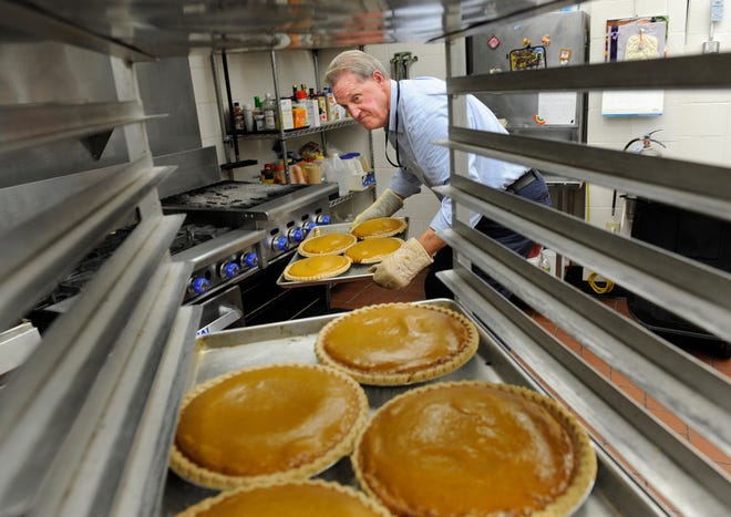 Delton Whitaker of Morton pulls four of the 400 pumpkin pies Monday he and other volunteers will produce for Thanksgiving Day at the South Side Mission. Each pie will provide eight slices for a total of 3,200 slices of pie that will be delivered with Thanksgiving meal. As of Monday, the mission had taken 2,000 requests for a holiday meal delivery with another 1,000 requests expected by Thursday.