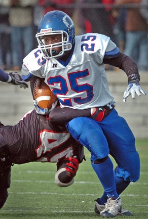 Quincy's Jalen Green (25) carries the ball but is tackled by North Quincy's Walter Hannon.