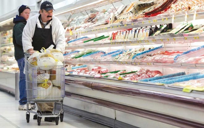 Supermarket manager Dennis Sheehan pushes a shopping cart full
of turkeys at an Akron, N.Y., grocery store on Tuesday.