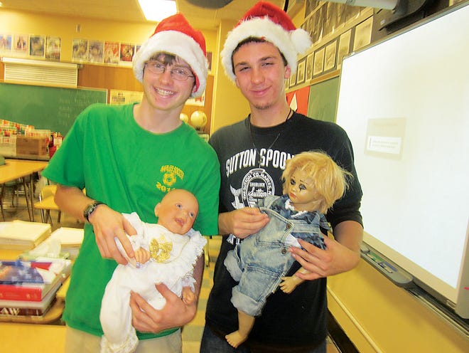 From left, Ben Pulver and Adam Halladay show off dolls that will be gifts for Naples children through Operation Santa.