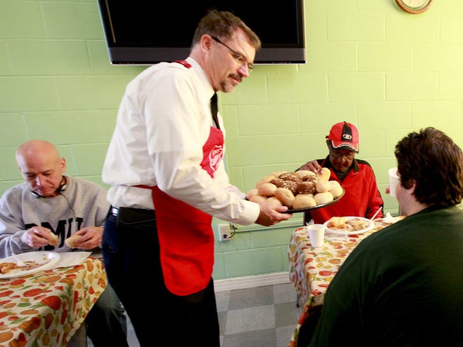 Lieutenants Preston Lewis serves dinner rolls at the Salvation Army on Thanksgiving day in Gainesville, Fla.