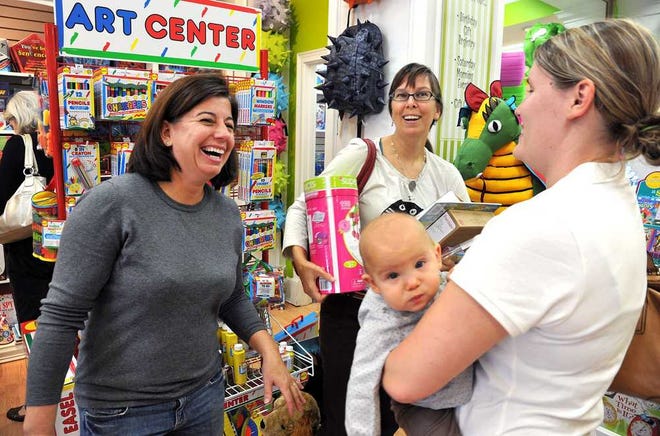 Bruce.Lipsky@jacksonville.com Sandi White (from left), owner of The Green Alligator, greets customers Anna Podris and Smith Podris, holding 6-month-old Catherine Anne. The two sisters-in-law, who are in town visiting family, make a habit of shopping local.