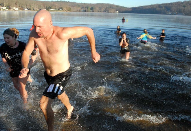 Dan Williams, of Plainfield, runs out of the water during the 18th annual Panther Plunge at Moosup Pond on Thanksgiving morning.
Aaron Flaum/ NorwichBulletin.com
