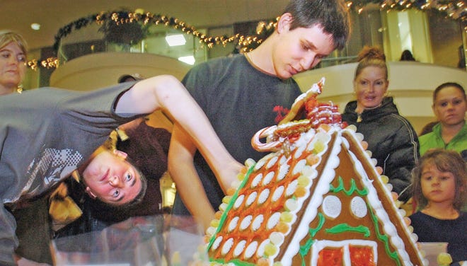 Michael Mullaney, left, 14, and Michael Killilea, 16, students at North Quincy High School, participate in the gingerbread house decorating contest during holiday festivities at Presidents Place in Quincy on Friday, Nov. 25, 2011.