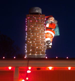 Santa climbs the chimney on Moore's roof, in Braintree, Saturday, Nov. 12, 2011.