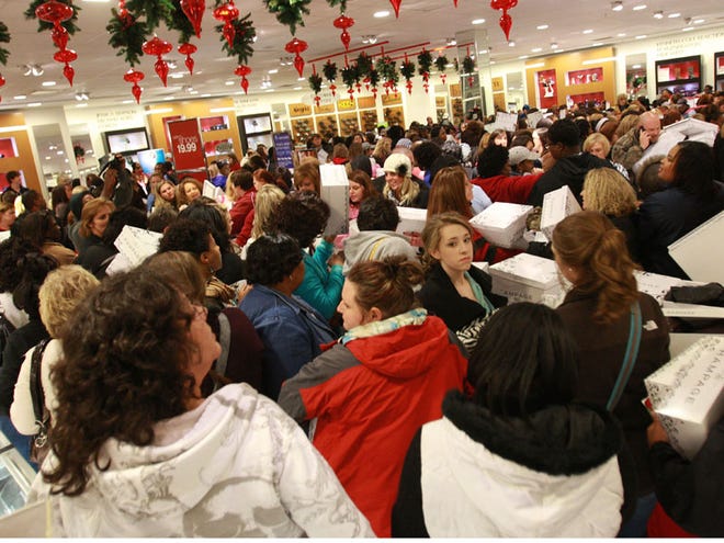Shoppers fight their way through the women’s shoe section inside Belk department store at University Mall for its opening at 3 a.m. on Black Friday.