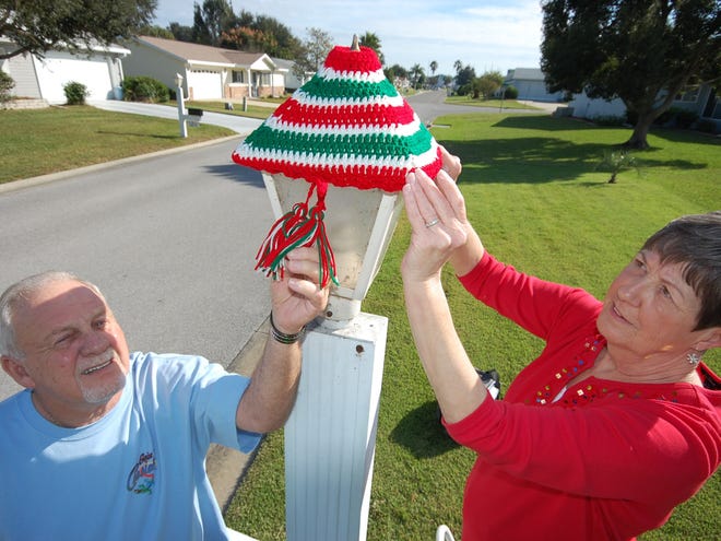 Bill and Pam Aper top a lamppost with a bonnet.