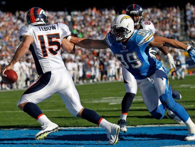 Denver Broncos quarterback Tim Tebow (15) runs under pressure from San Diego Chargers outside linebacker Travis LaBoy during the first half of an NFL football game on Sunday, Nov. 27, 2011, in San Diego. (The Associated Press)