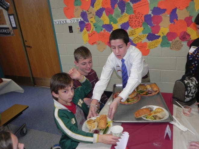 Brenden Shoels, 11, of Franklin, serves food at the annual Fall Feast at Franklin Elementary School.