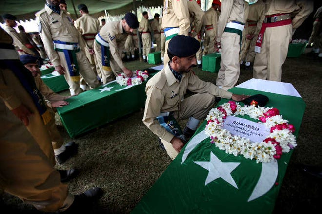 A Pakistani soldier pays tribute to colleagues who lost their lives in a Saturday’s NATO attack, during funerals Sunday in Peshawar.