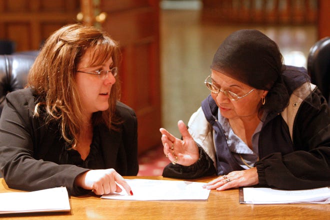 Brockton City Councilor Michelle DuBois, left, talks with Rita Teixeira-Fontes of Brockton about her water bill at City Hall on Monday.