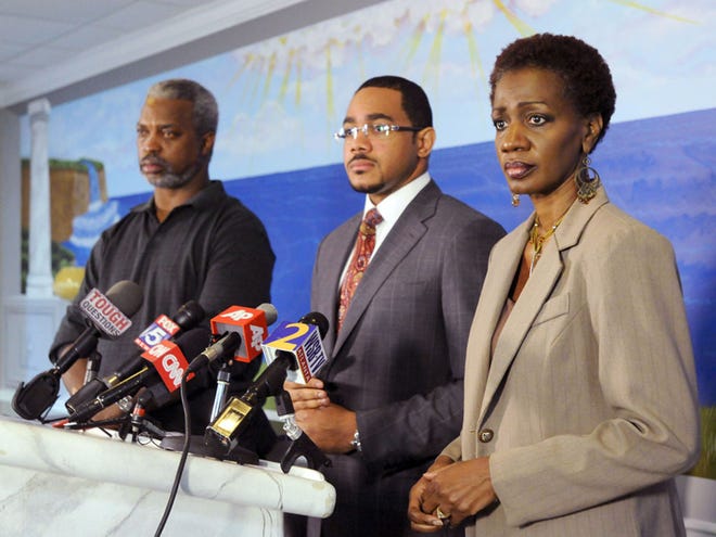 Robert Champion Sr, left, his wife, Pam, right, and their attorney Christopher Chestnut participate in a news conference on Monday, Nov. 28, 2011, in Lithonia, Ga. The Champions, parents of Florida A&M drum major Robert Champion who died of suspected hazing Nov. 19, in Orlando, Fla., said they plan on filing a civil lawsuit in the matter. (AP Photo/Erik S. Lesser)