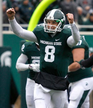 Michigan State quarterback Kirk Cousins (8) celebrates a touchdown during the first quarter of an NCAA college football game against Indiana, Saturday, Nov. 19, 2011, in East Lansing, Mich. Michigan State won 55-3.