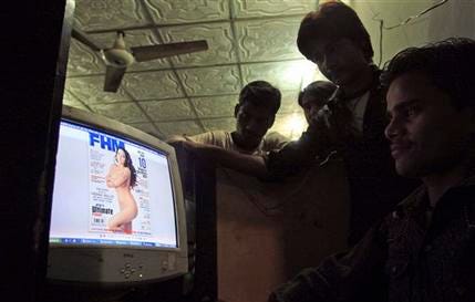 Pakistanis look at a website displaying Veena Malik's photo on the website of FHM India, at an Internet cafe in Karachi, Pakistan, Saturday, Dec. 3, 2011.
