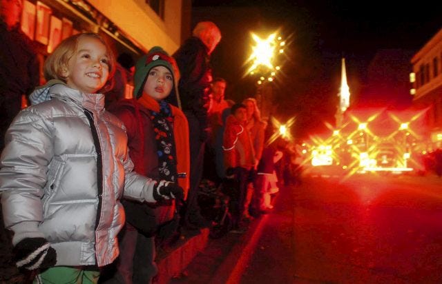 John Huff/Staff photographer 
Jesse Court, 5, left, and Lyric Slocum, 5, cheer on floats as the watch this year's Portsmouth Holiday Parade Saturday evening.