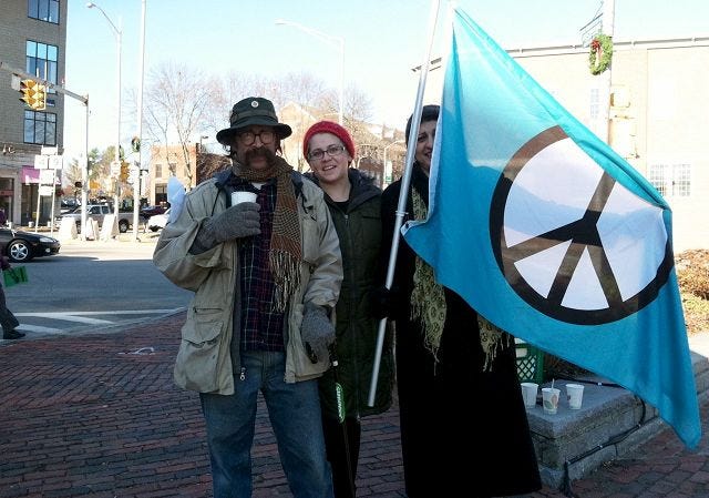 Ramsdell/Democrat photo
Wes Flierl, left, Lindsey, center, and Nur Shoop, right, stand at Henry Law Park Saturday afternoon for a demonstration with Occupy N.H. at Dover.